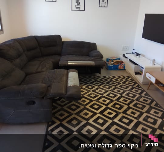 ספה פינתית כהה על שטיח גיאומטרי שחור לבן